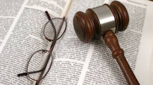 Gavel and pair of glasses on open book