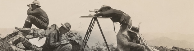 A sepia toned historic photograph shows four men surveying