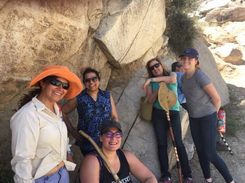 People in a desert setting, smiling